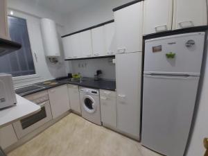 a white kitchen with a refrigerator and a dishwasher at Apartamento Ideal Retiro - Centro de Madrid in Madrid