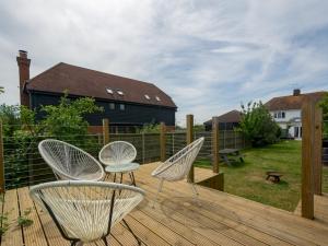 2 sillas blancas sentadas en una terraza de madera en Pass the Keys Four bed family home close to country and coast en Herne Bay