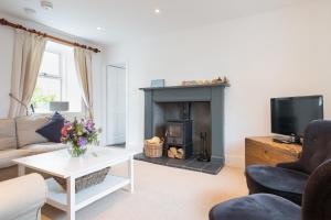 a living room with a fireplace and a tv at Seaside cottage on Moray coast in Portknockie