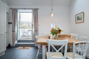 a kitchen and dining room with a wooden table and chairs at Seaside cottage on Moray coast in Portknockie
