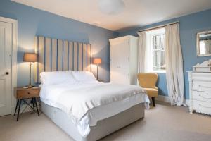 a bedroom with a large white bed and blue walls at Seaside cottage on Moray coast in Portknockie