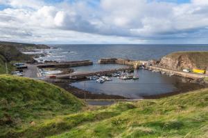 a group of boats docked at a dock in the water at Seaside cottage on Moray coast in Portknockie