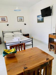 Zimmer mit einem Tisch, einem Bett und einem TV in der Unterkunft Camelia Studios in Yénion