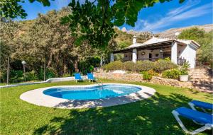 een zwembad in een tuin met twee stoelen en een huis bij 2 Bedroom Beautiful Home In Alora in Alora