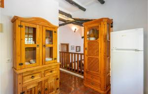 een keuken met een houten kast en een koelkast bij 2 Bedroom Beautiful Home In Alora in Alora