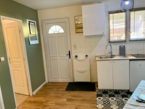 a kitchen with a white door and a sink at Superbe appartement avec parking gratuit sur place in Saint-Denis +7 photos