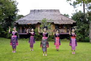 Un gruppo di ragazze che si trovano davanti a una capanna di Hmong Hilltribe Lodge a Mae Rim