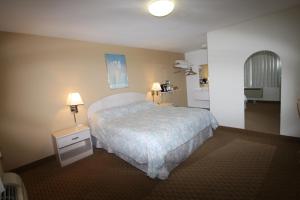 a hotel room with a bed and a bathroom at Redwood Inn in Santa Rosa