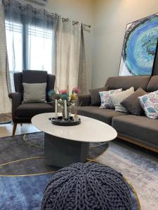 班珠尔Modern 2-bedroom unit with pool and beach access的客厅里有一张沙发和一张摆满鲜花的桌子