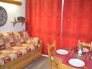 a living room with a couch and a table with a table at Studio Les Menuires, 1 pièce, 3 personnes - FR-1-452-3 in Les Menuires