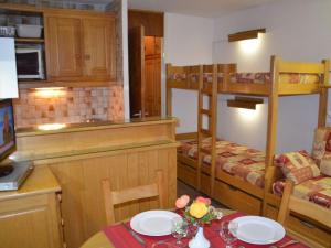 a room with a table and a kitchen with bunk beds at Studio Les Menuires, 1 pièce, 3 personnes - FR-1-452-3 in Les Menuires