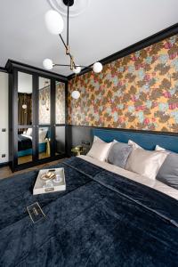 1 dormitorio con 1 cama grande con alfombra azul en Gdańsk Tarasy Bałtyku Sea Side by Downtown Apartments - Sauna, Gym & Parking en Gdansk