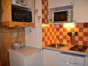 een kleine keuken met een wastafel en een magnetron bij Studio Les Menuires, 1 pièce, 2 personnes - FR-1-452-12 in Les Menuires