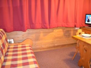een woonkamer met een rood gordijn en een tafel bij Studio Les Menuires, 1 pièce, 2 personnes - FR-1-452-12 in Les Menuires
