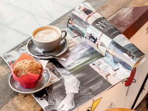 ibis Sydney Barangaroo في سيدني: كوب قهوة وقطعة كيك على طاولة