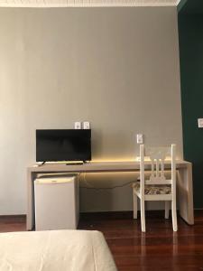 Cette chambre comprend un bureau avec un ordinateur et une chaise. dans l'établissement Pousada Portas da Amazônia, à São Luís