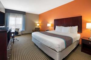 a hotel room with a large bed and a desk at La Quinta by Wyndham Houston IAH Bush Intl Airport E in Humble