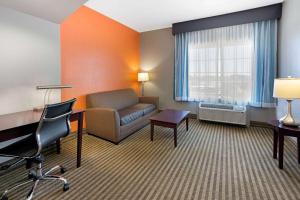 a hotel room with a couch and a desk and a window at La Quinta by Wyndham Houston IAH Bush Intl Airport E in Humble