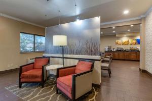 a lobby with chairs and a counter with a kitchen at Comfort Inn & Suites Waterloo - Cedar Falls in Waterloo