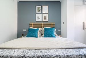 a bedroom with blue walls and a bed with blue pillows at Apartamento Mani en Avenida España con terraza in Albacete