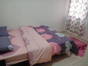 a bedroom with a bed with a flower patterned blanket at Debayu Homestay with Free Parking at Setia Alam in Shah Alam