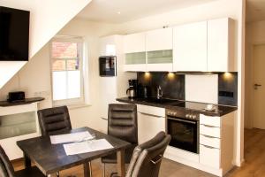 a kitchen with a table and a dining room at Residenz Whg 2 in Norddeich