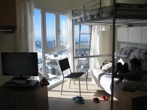 una persona sentada en una cama en un dormitorio con ventana en Precioso apartamento a pie de pista en Sierra Nevada en Sierra Nevada