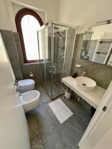a bathroom with a shower and a toilet and a sink at Aci Boutique Apartment in Acitrezza