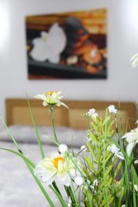 eine Vase voller weißer Blumen auf dem Tisch in der Unterkunft Han Pizza&Pasta in Domneşti