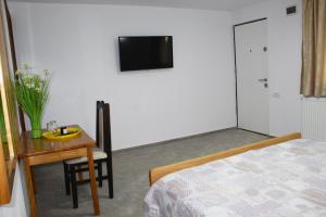 a bedroom with a table and a bed and a television at Han Pizza&Pasta in Domneşti