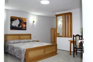 Schlafzimmer mit einem Bett, einem Tisch und einem Spiegel in der Unterkunft Han Pizza&Pasta in Domneşti