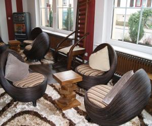 a living room with three chairs and a rug at Hotel-Restaurant Bürgerstuben in Lebach