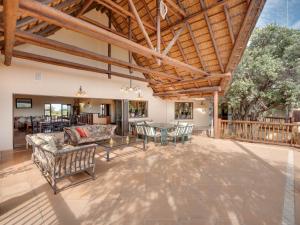 ein Wohnzimmer im Freien mit Holzdecke in der Unterkunft Luxurious 4 Bedroom Villa with Cottage 205 in Mabula