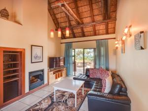 ein Wohnzimmer mit Sofa und Tisch in der Unterkunft Luxurious 4 Bedroom Villa with Cottage 205 in Mabula