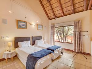 ein Schlafzimmer mit zwei Betten und einem großen Fenster in der Unterkunft Luxurious 4 Bedroom Villa with Cottage 205 in Mabula + 10 Fotos