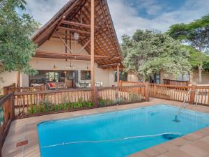 ein Swimmingpool vor einem Haus in der Unterkunft Luxurious 4 Bedroom Villa with Cottage 205 in Mabula