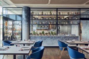 a restaurant with tables and chairs and a bar at Falkensteiner Residences Jesolo in Lido di Jesolo