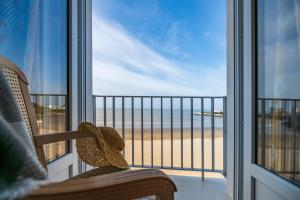 a room with a view of the beach through a window at CERISE Royan - Le Grand Hôtel de la Plage in Royan