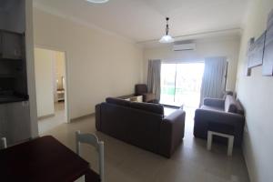 uma sala de estar com um sofá, cadeiras e uma mesa em Saints View Resort Unit 1 em Uvongo Beach