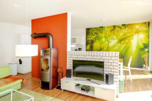 ein Wohnzimmer mit einem Kamin und einer orangefarbenen Wand in der Unterkunft Traumfängerloge -Hafenresidenz in Waren (Müritz)