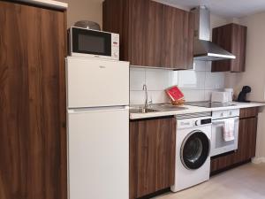 a kitchen with a white refrigerator and a microwave at La Casona del Eboni in Alcalá de Henares