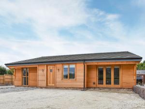 a wooden cabin with a lot of windows at Redstones Cottage in Greasby