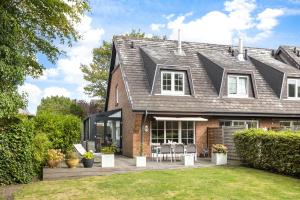 a house with a patio with chairs in the yard at Ferienhaus Frieda Sylt in Tinnum