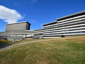 um grande edifício com um campo de relva em frente em Studio Les Menuires, 1 pièce, 3 personnes - FR-1-452-98 em Les Menuires