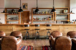 a bar with brown leather chairs and a counter at Rooms Hotel Kazbegi in Kazbegi