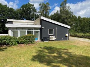a small black house sitting on top of a yard at 7 person holiday home in rsted in Kare