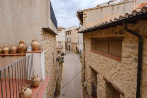 an alley with vases sitting on a balcony at Cal Manso in Arnés