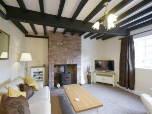 a living room with a couch and a fireplace at The Retreat in Whitchurch
