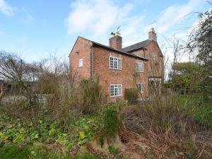 an old brick house in the middle of a field at The Retreat in Whitchurch