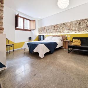 a bedroom with a large bed and a stone wall at El 32 in Lorca